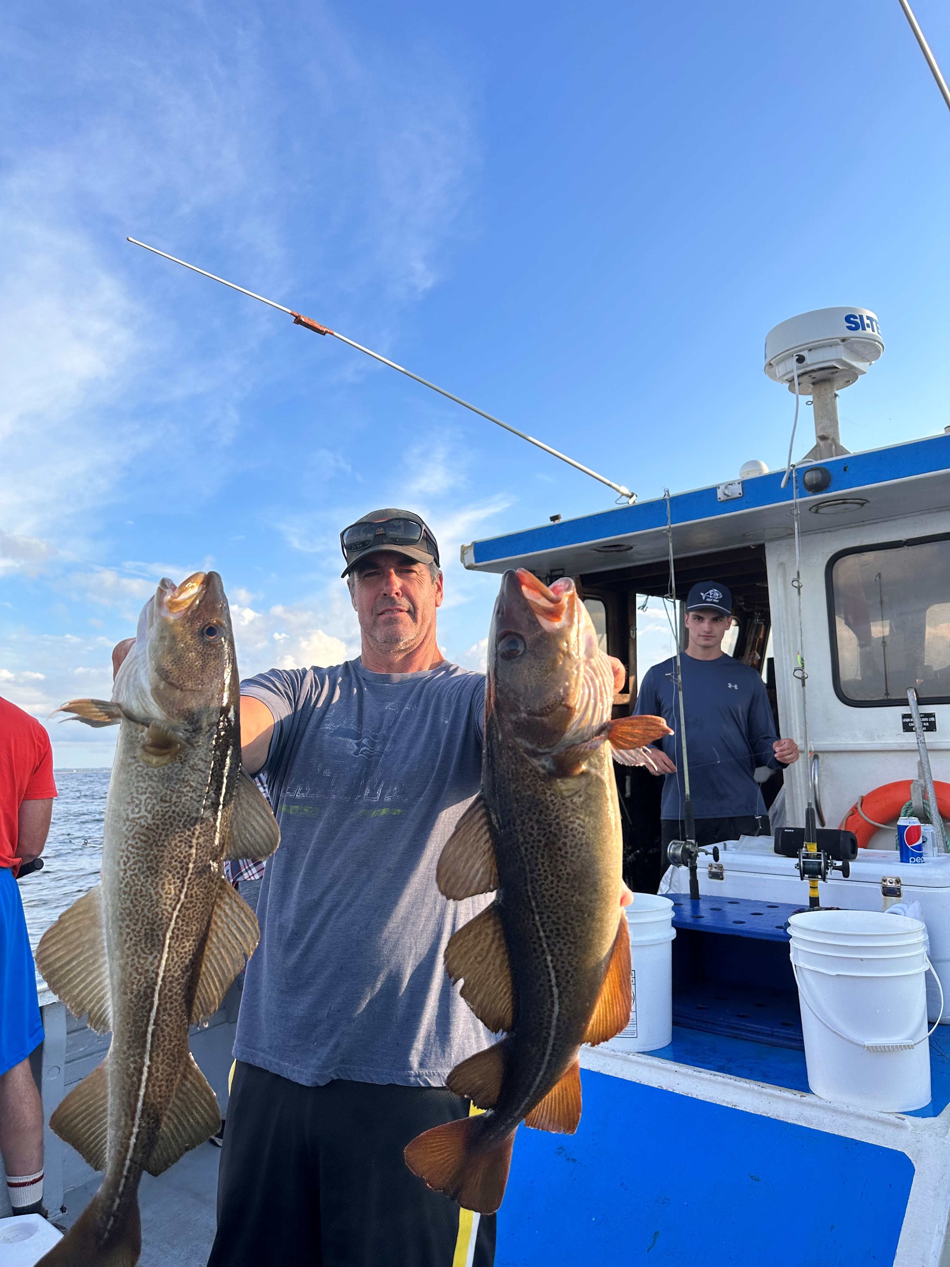 Man holding 2 fish he caught on Campbell's. Deep Sea Fishing Boat Tours